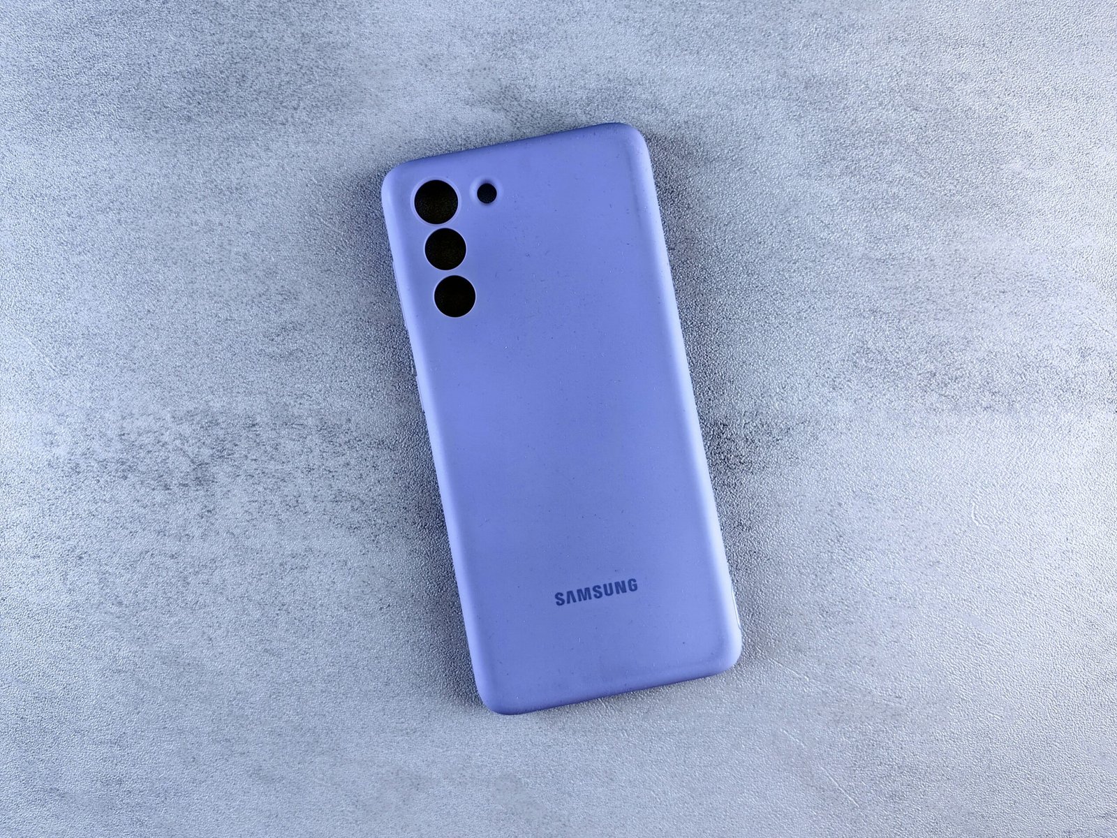 a blue samsung phone laying on a white surface
